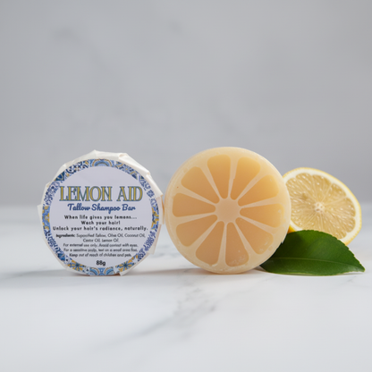 Angled view of the Lemon Aid Tallow Shampoo Bar with a fresh lemon half and leaf