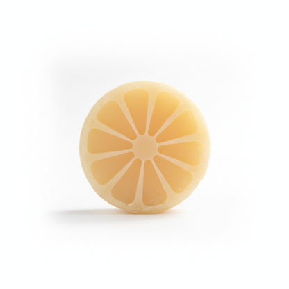 Plain lemon-slice shaped Lemon Aid tallow shampoo bar on a white background