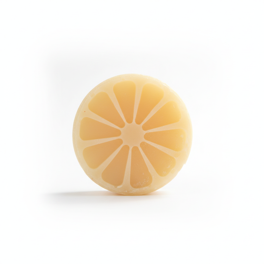 Plain lemon-slice shaped Lemon Aid tallow shampoo bar on a white background